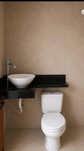 a bathroom with a white toilet and a sink at Casa dos bons encontros in Santa Isabel