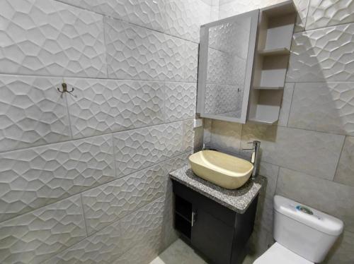 a white bathroom with a sink and a toilet at Casa Central in Cuenca