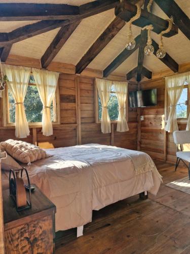 a bedroom with a bed in a room with wooden walls at San Pedro Atmatla Zacatlan Cabins in Zacatlán