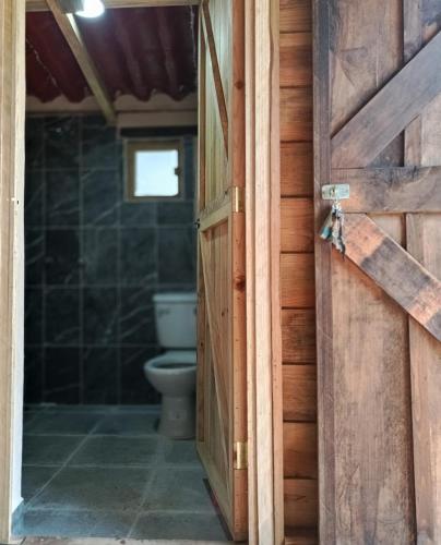 an open door to a bathroom with a toilet at San Pedro Atmatla Zacatlan Cabins in Zacatlán