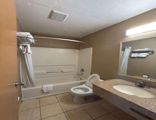 a bathroom with a sink and a toilet and a tub at Super 8 by Wyndham Topeka/Wanamaker RD/I-70 in Topeka