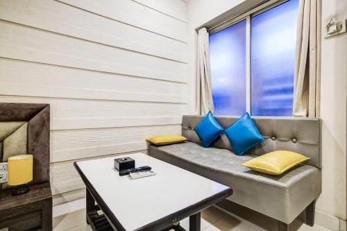 a room with a couch and a table at Super Townhouse Dewas City Formerly Utsav in Dewās