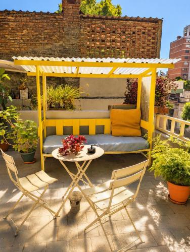 a yellow gazebo on a patio with a table and chairs at Youki Haus Hostel in Montevideo