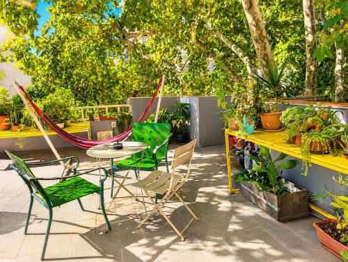 a patio with a table and chairs and plants at Youki Haus Hostel in Montevideo