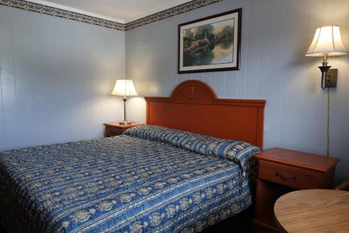 a hotel room with a bed and two lamps at Starlite Motel in Heath