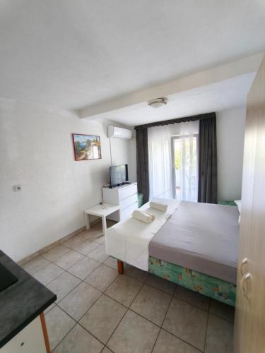a bedroom with a large bed and a television at Apartments Šešo B in Pag
