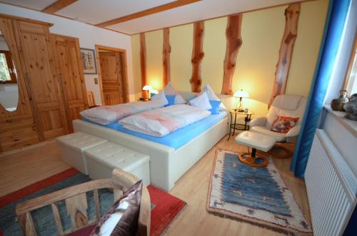 ein Schlafzimmer mit einem Bett und einem Stuhl in der Unterkunft Ferienwohnung im Harz-Haus-Bruns in Clausthal-Zellerfeld