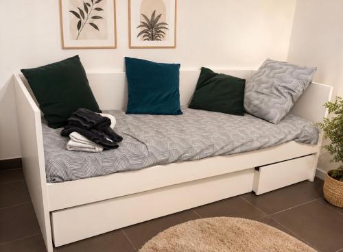 a white couch with blue pillows on it at Rose CosyHome Paris Champs in Champs-sur-Marne