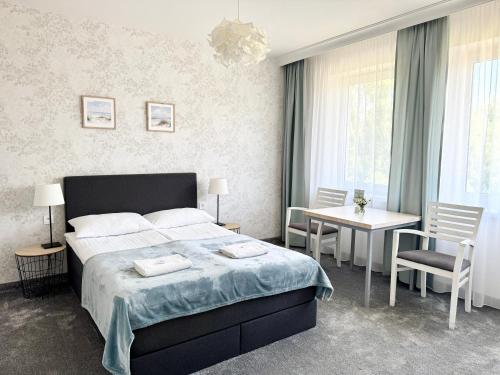 a bedroom with a bed and a table and chairs at Biały Domek - STREFA CISZY, CHILDREN FREE in Dźwirzyno