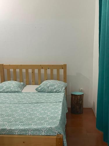a small bedroom with a bed and a table at Old house in Tarrafal