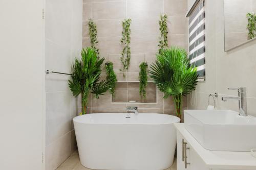 a bathroom with two sinks and a tub and plants at Edenvale corner in Edenvale