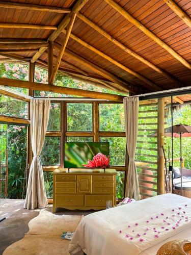 a bedroom with a bed and a flat screen tv at Villa Pantai Secret Place in Miracatu