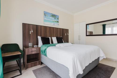 a bedroom with a large bed and a chair at Edenvale corner in Edenvale