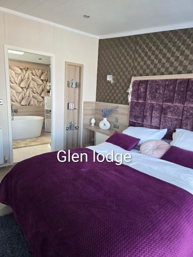 a bedroom with a purple bed and a bath tub at Glen lodge Craig Tara in Ayr