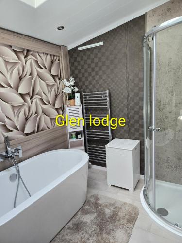 a bathroom with a large tub and a shower at Glen lodge Craig Tara in Ayr