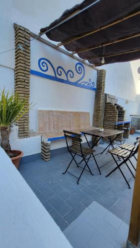 a patio with a table and chairs and a wall at Cádiz Playa La Caleta Terraza con Barbacoa in Cádiz