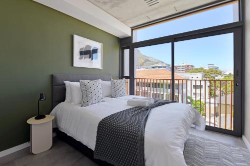 a bedroom with a bed and a large window at SIX ON N - Fluent Serviced Apartments in Cape Town
