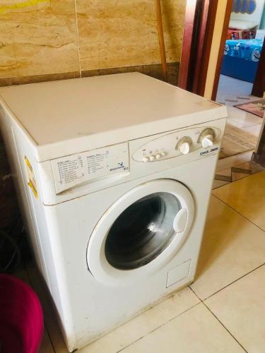 a white washing machine sitting in a room at نورس هوم in Al Ghuşnah