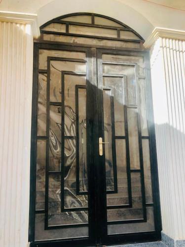 a glass door with a painting on a wall at نورس هوم in Al Ghuşnah