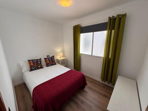 a small bedroom with a bed and a window at Casa Rosales in La Orotava