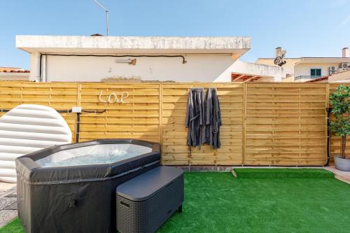 a backyard with a hot tub and a fence at The Quinta & Studios in Quinta do Conde