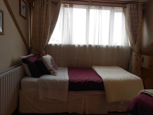 a small bed in a room with a window at Portland House in Dublin