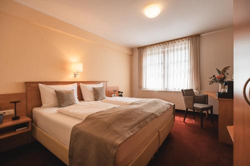 a hotel room with a large bed and a window at Filet & Freunde in Oelsnitz