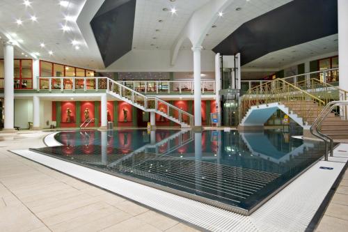 een groot zwembad in een gebouw met een trap bij Hotel Luisa in Františkovy Lázně