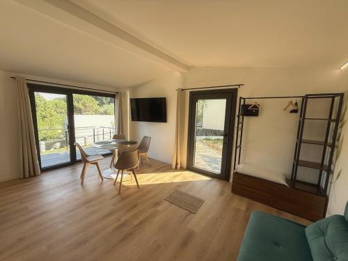 a living room with a table and chairs at Amici del Colle - Olive Tiny Houses in Borgo a Buggiano