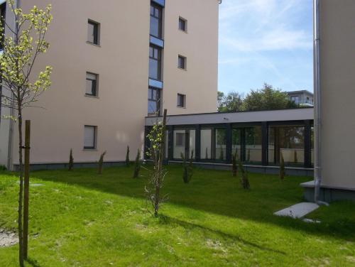 a building with a green yard next to a building at Lagrange Aparthotel Toulouse Saint-Michel in Toulouse