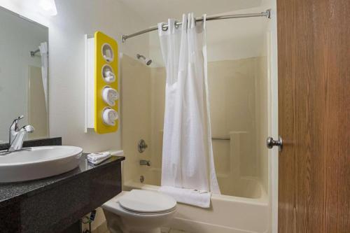 a bathroom with a toilet and a sink and a shower at Atlantic Inn Marshalltown, Iowa in Marshalltown