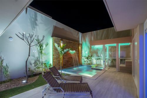 a living room with a swimming pool and chairs at Leblon Motel in Barretos