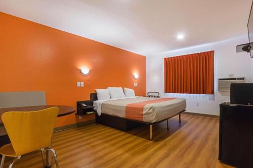 a hotel room with a bed and a desk and chair at Atlantic Inn Marshalltown, Iowa in Marshalltown