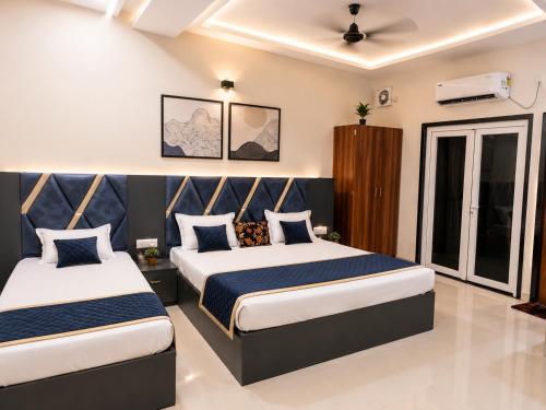 a bedroom with two beds in a room at Hotel Atlas in Raigarh