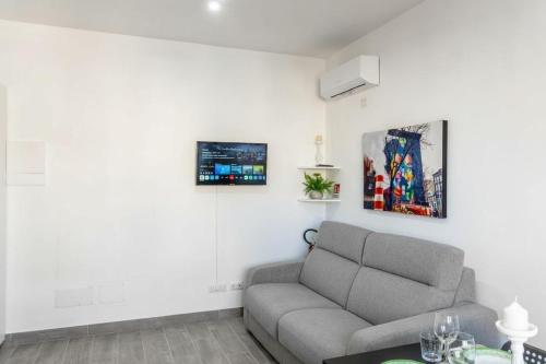 a living room with a couch and pictures on the wall at Enjoy and Fly, NEAR THE AIRPORT AND THE SEA in Fiumicino