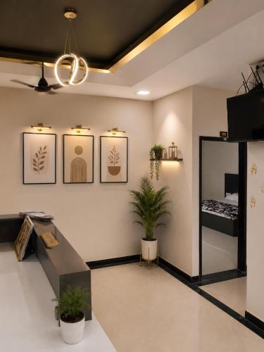 a room with two plants and a bed on the wall at Hotel Atlas in Raigarh