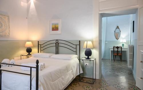 a bedroom with a large white bed with two lamps at Dimora San Vito in Lequile