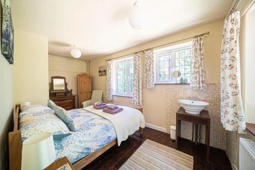 a bedroom with a bed and a sink at Primrose Spinney in Ringwood