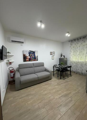 a living room with a couch and a table at Enjoy and Fly, NEAR THE AIRPORT AND THE SEA in Fiumicino