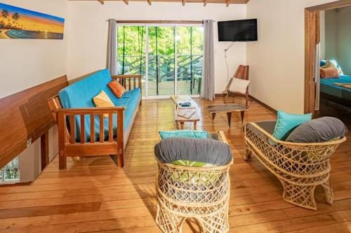a living room with a blue couch and chairs at 2 Coco Locos at Sunset in Seine Bight Village