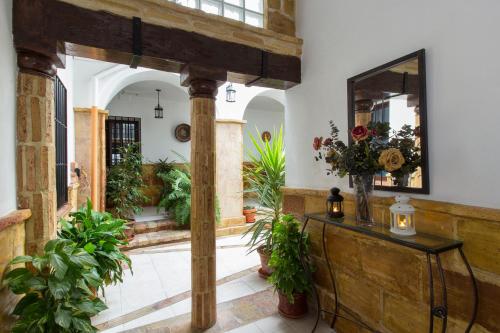 een hal met een spiegel en een tafel met planten bij Casa Turística Patio Cordobés - Parking privado en la Judería in Córdoba