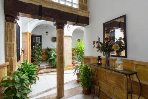コルドバにあるCasa Turística Patio Cordobés - Parking privado en la Juderíaの鏡と植物のテーブルが備わる廊下