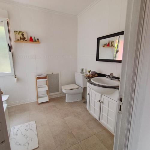 a white bathroom with a sink and a toilet at Casa Dulce in Villaviciosa