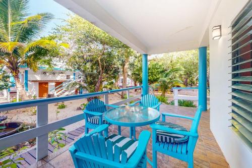 a balcony with blue chairs and a glass table at Condo #25 @ Beachside Villas in Placencia