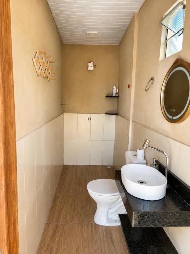 a bathroom with a toilet and a sink at Chácara Aconchegante com Piscina e Churrasqueira Perto do Ponto Turístico de Bezerros in Bezerros