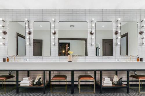 a bathroom with two chairs and a large mirror at Eleven48 Hotel in New Orleans