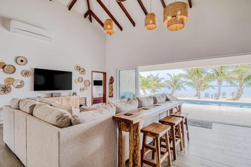 a living room with a large couch and a table at Tres Palmas Beach House in Maya Beach