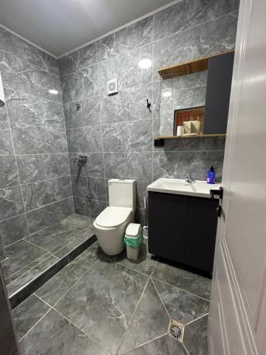 a bathroom with a toilet and a sink at MMED SWEET HOMe in Bosteri