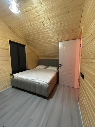 a small bedroom with a bed and a door at MMED SWEET HOMe in Bosteri