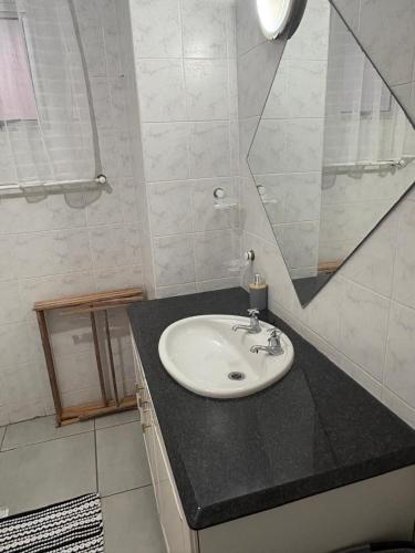 a bathroom with a sink and a mirror at Oceans Whisper 704 beach apartment gated & Lift access in Scottburgh